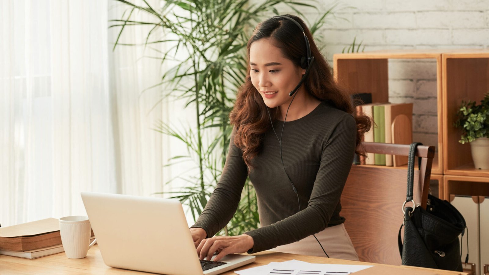 Pretty female technical support operator answering e-mails